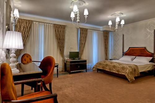 比亚韦斯托克桑塔纳酒店的一间卧室配有一张床、一张桌子和一台电脑