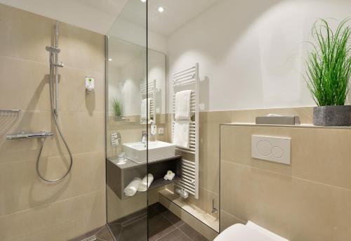 汉堡汉堡明智时光公寓式酒店的带淋浴、卫生间和盥洗盆的浴室