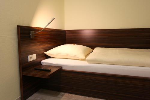 小布利特斯多夫阿特尔佐尔酒店的一间卧室配有一张带木制床头板的床