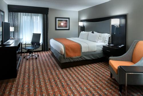 安条克Holiday Inn Express & Suites Nashville Southeast - Antioch, an IHG Hotel的酒店客房,配有一张床、一张桌子和椅子