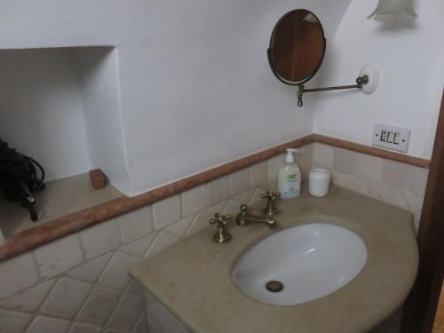 阿尔贝罗贝洛Trullo Vacanza的浴室设有白色水槽和镜子