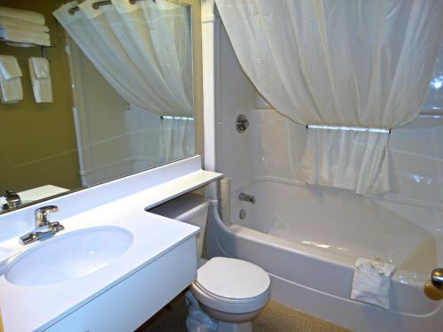 蒙克顿阿姆斯特丹蒙克顿套房酒店的浴室配有盥洗盆、卫生间和浴缸。