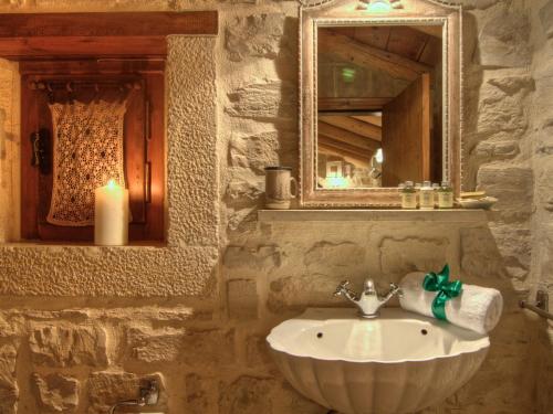 普林斯Villa Anastasia的石质浴室设有水槽和镜子