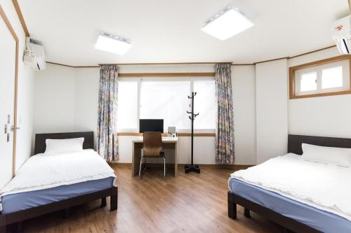 首尔克里宾馆的一间卧室配有两张床和一张带电脑的书桌