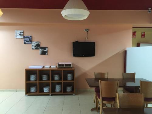 拉洪克拉拉洪奎拉酒店的一间设有桌子和墙上电视的用餐室
