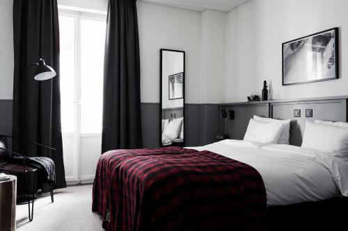 英格堡英格堡滑雪酒店的一间黑白卧室,配有一张床和镜子