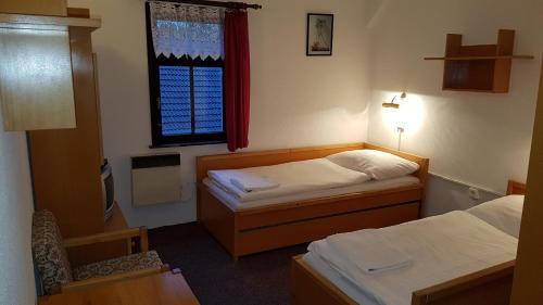 PřeštěnicePenzion Přeštěnice的小房间设有两张床和窗户