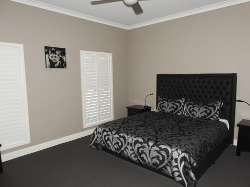 拉瑟格伦巴克利套房公寓的一间卧室设有黑白床和2个窗户。