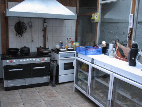 蓬塔阿雷纳斯埃尔米拉多旅馆的厨房配有炉灶和台面