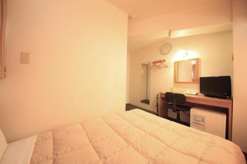 府中市武藏野之森酒店的一间卧室配有一张床和一张带电脑的书桌