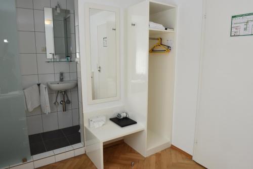 胡根尔舍姆赫施巴迪彻兰德霍夫旅馆的一间带水槽和镜子的浴室