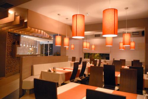 桑丹斯基安飞士酒店的用餐室配有桌椅和吊灯。