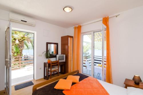 波拉斯Apartments Matana Chano的一间卧室配有带橙色枕头的床和阳台