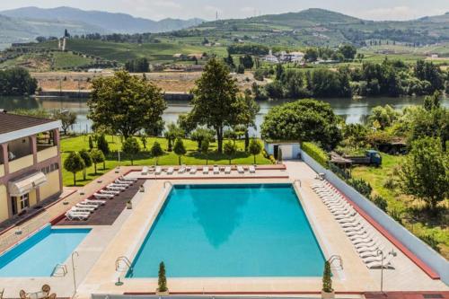 比索达雷加Hotel Columbano的享有游泳池的顶部景色,河流背景
