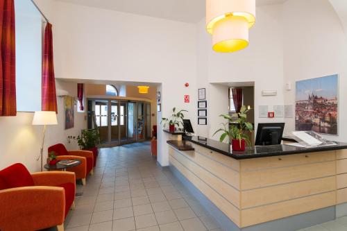 布拉格埃克城市公园酒店的医院的大厅,里面摆放着橙色椅子和柜台