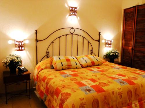 瓦哈卡市Hotel Dainzu的一间卧室配有一张大床和两个灯