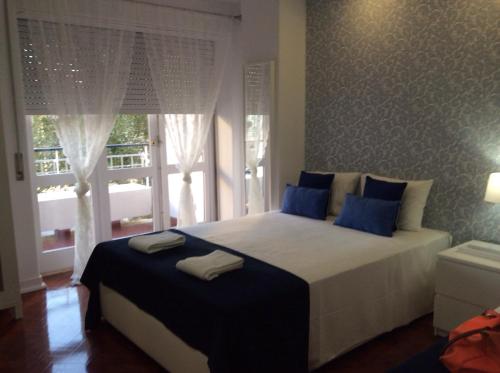 里斯本4U Lisbon IV Guesthouse Airport的一间卧室配有一张带蓝色枕头的床和一扇窗户。