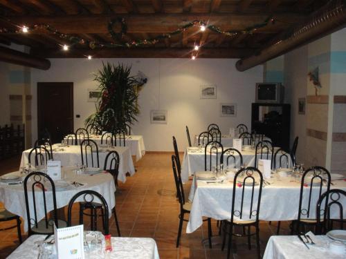 曼托瓦诺港Agriturismo La Rasdora的配有桌椅和白色桌布的房间