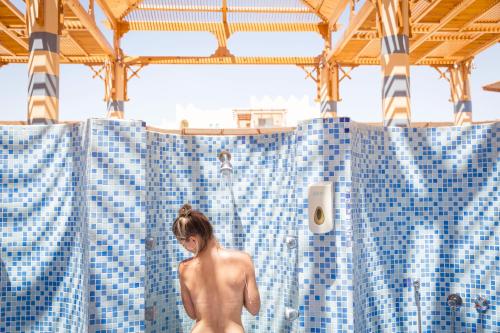 赫尔格达Robinson Soma Bay的女人站在蓝色瓷砖淋浴间里