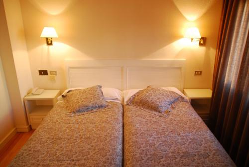 仕格莱伊瓜莱纳酒店的一间卧室配有两张带枕头的床。