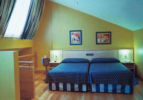 伊斯拉北极星酒店的一间卧室配有一张带蓝色和白色棉被的床