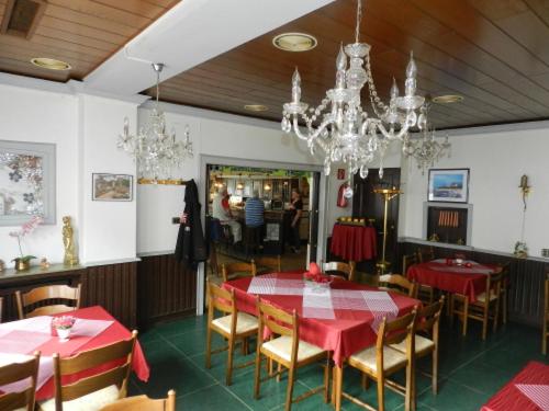 多特蒙德Hotel In der Meile的一间用餐室,配有红色的桌椅和吊灯