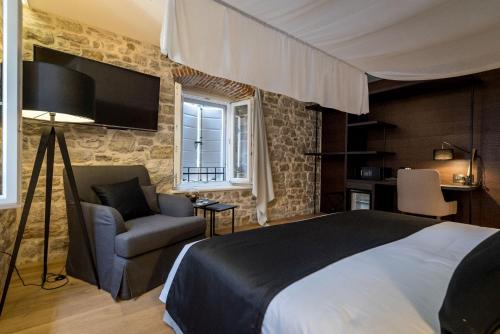 斯普利特穆鲁姆遗产酒店的一间卧室配有一张床、一张沙发和一台电视。