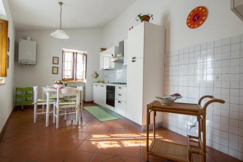 斯佩洛Casa Flora的厨房配有白色橱柜和桌子
