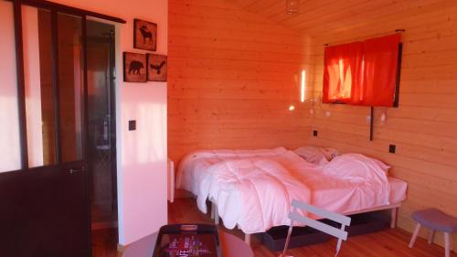 Fréchou-Fréchet猎鹰度假屋的木制客房内的一间卧室,配有一张床