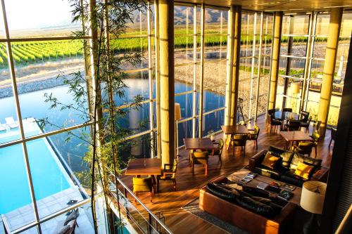 Los Árboles葡萄园红酒度假酒店的享有带大玻璃墙的客房的景致。