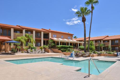 土桑3 Palms Tucson North Foothills的一个带游泳池和棕榈树的度假村