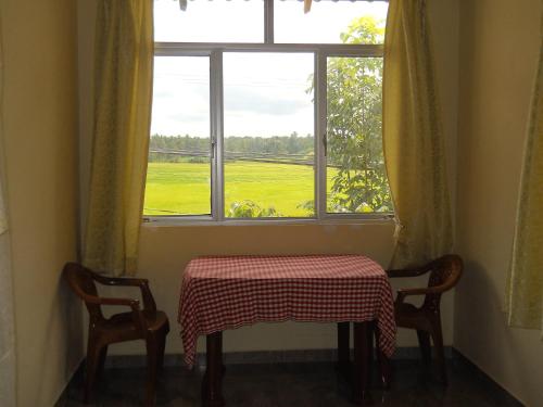波隆纳鲁沃日落旅游之家民宿的窗前的一张桌子和两把椅子