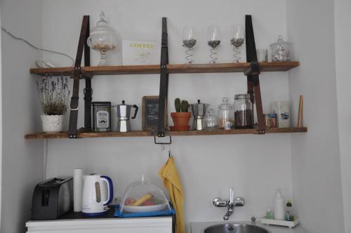 比尔B&B im Herzen von Biel的厨房配有带玻璃杯和水槽的木制架子