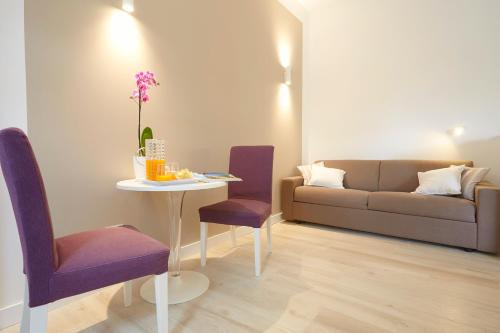 蒙德罗B&B Mondello Design的客厅配有沙发、桌子和紫色椅子