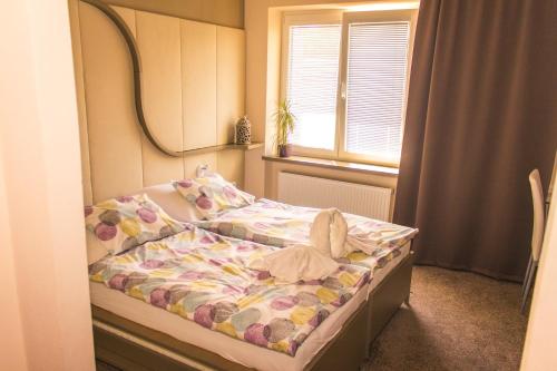 Fulnek雷莱克酒店的一间小卧室,配有一张带镜子的床