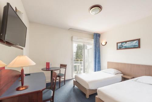 昂蒂布Appart'City Classic Antibes的酒店客房设有两张床和窗户。