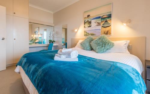 Encounter Bay布拉夫公寓度假村的一间卧室配有一张大床和毛巾