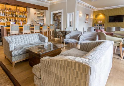 温德米尔兰普莱特尔餐厅及客房酒店的带沙发和桌子的客厅以及酒吧。