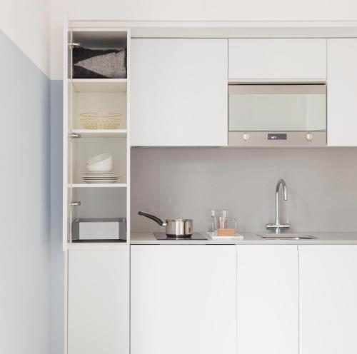 伦敦莱蒙洛克公寓式酒店的白色的厨房配有白色橱柜和水槽