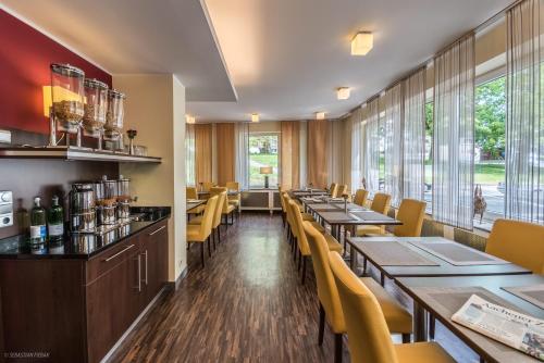 亚琛劳兹贝格酒店的餐厅设有木桌和黄色椅子