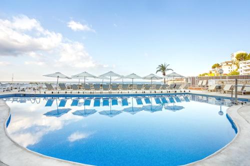 马略卡岛帕尔马玛里文特仅限成人活跃酒店的一个带椅子和遮阳伞的大型游泳池