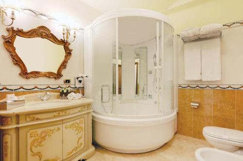奥尔比亚总统大酒店的带浴缸、盥洗盆和卫生间的浴室