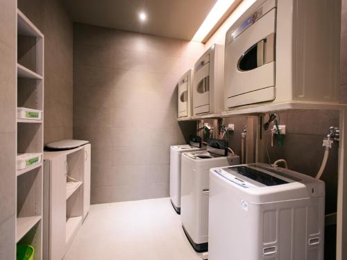 高雄奇异果快捷旅店（高雄九如店） 的洗衣房配有3台洗衣机和烘干机