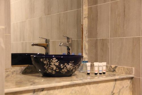 努瓦克肖特卡萨布鲁酒店的浴室设有黑色碗水槽和镜子