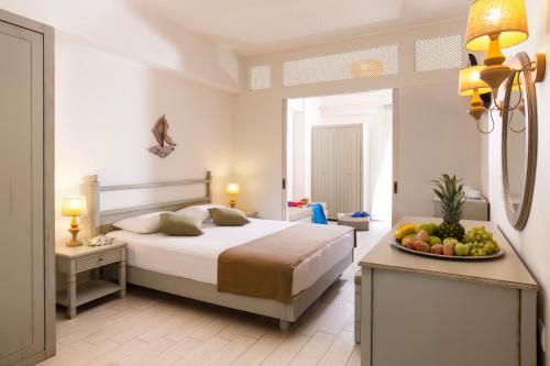 阿尔米里达阿尔米利达度假酒店的一间卧室配有一张床和一碗水果