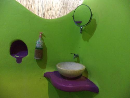 八丹拜托皮宾馆的绿色浴室设有水槽和镜子