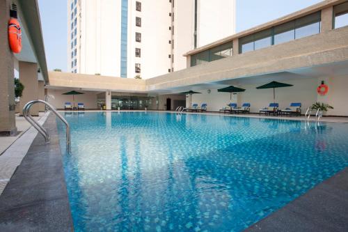 Quang Tri孟青大广治酒店 的一座带椅子和遮阳伞的大型游泳池