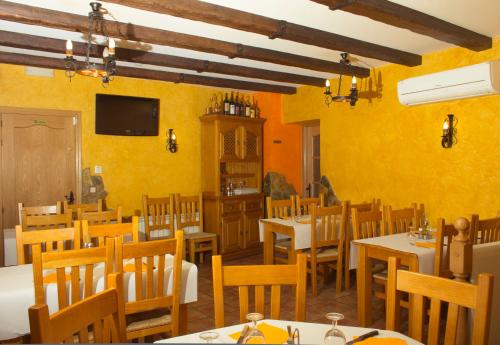 AtecaHostal El Bodegon的餐厅拥有黄色的墙壁和桌椅