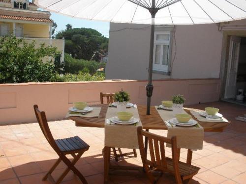 埃斯托利尔Villa Charme的庭院里配有桌椅和遮阳伞
