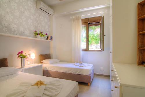 圣特里亚斯Villa Ikaros的小房间设有两张床和窗户